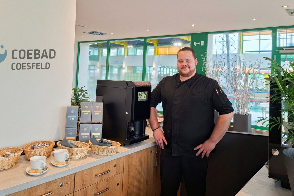 Ron Tücking, neuer Koch im Coebad steht in der Gastronomie und lächelt in die Kamera.