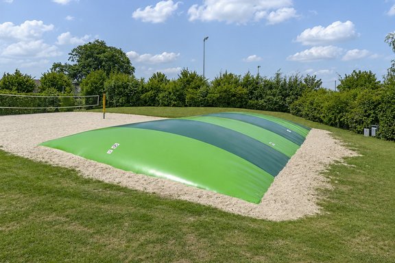 Das Bild zeigt das Hüpfkissen im Coebad. Es ist ein Teil vom Beachvolleyballfeld zu sehen.