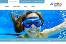 Die Webseite zeigt ein Mädchen, das im Wasser schwimmt, mit glitzernden Wellen und einem klaren Himmel im Hintergrund.