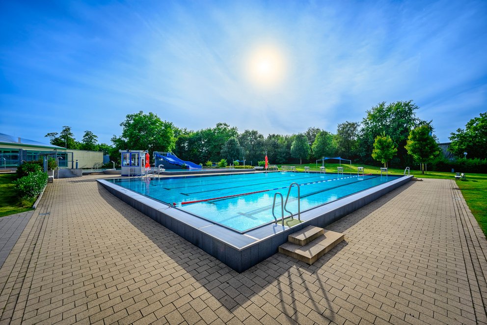 Schwimmbecken im Aussenbereich unter blauem Himmel Ein Schwimmbecken im Aussenbereich unter blauem Himmel, ideal für sportliches Schwimmen und Badespaß für alle Altersgruppen.