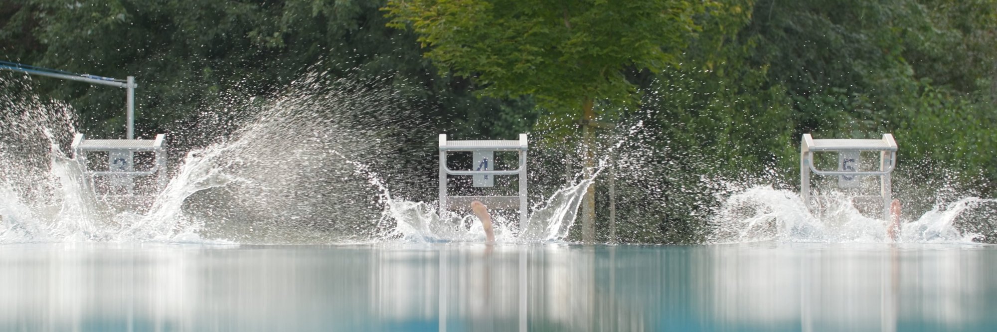 Spritziger Pool mit dynamischer Atmosphäre. Ein großer Pool, in dem Wasser spritzt, was eine dynamische und erfrischende Stimmung erzeugt.