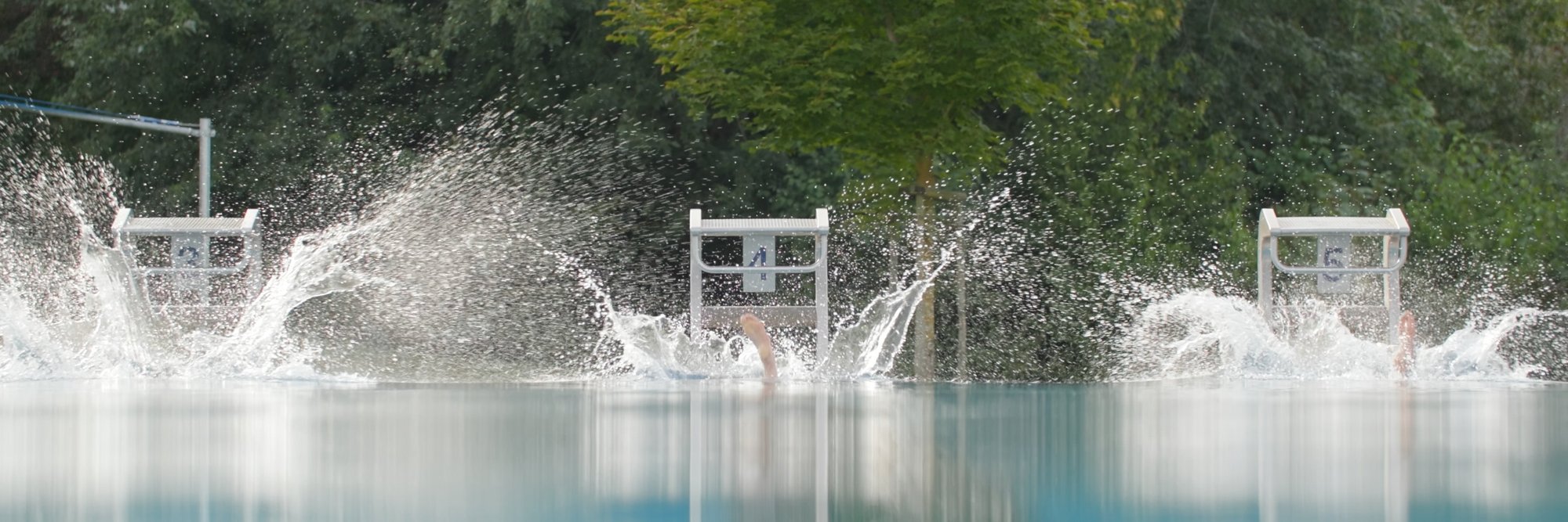 Spritziger Pool mit dynamischer Atmosphäre. Ein großer Pool, in dem Wasser spritzt, was eine dynamische und erfrischende Stimmung erzeugt.