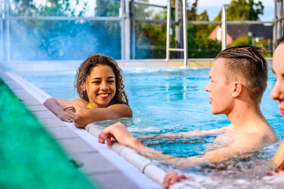 Sonnige Auszeit: Badevergnügen im Pool Mehrere Personen genießen das Schwimmen im Pool, während die Sonne auf die Wasseroberfläche scheint.