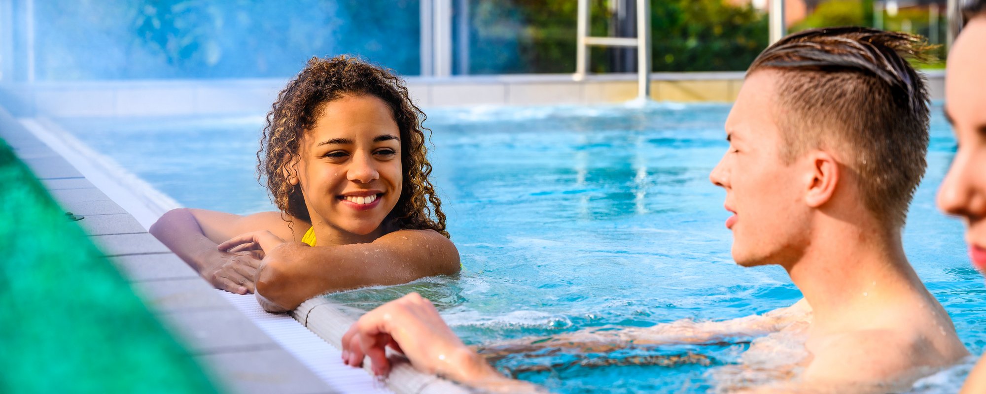 Sonnige Auszeit: Badevergnügen im Pool Mehrere Personen genießen das Schwimmen im Pool, während die Sonne auf die Wasseroberfläche scheint.