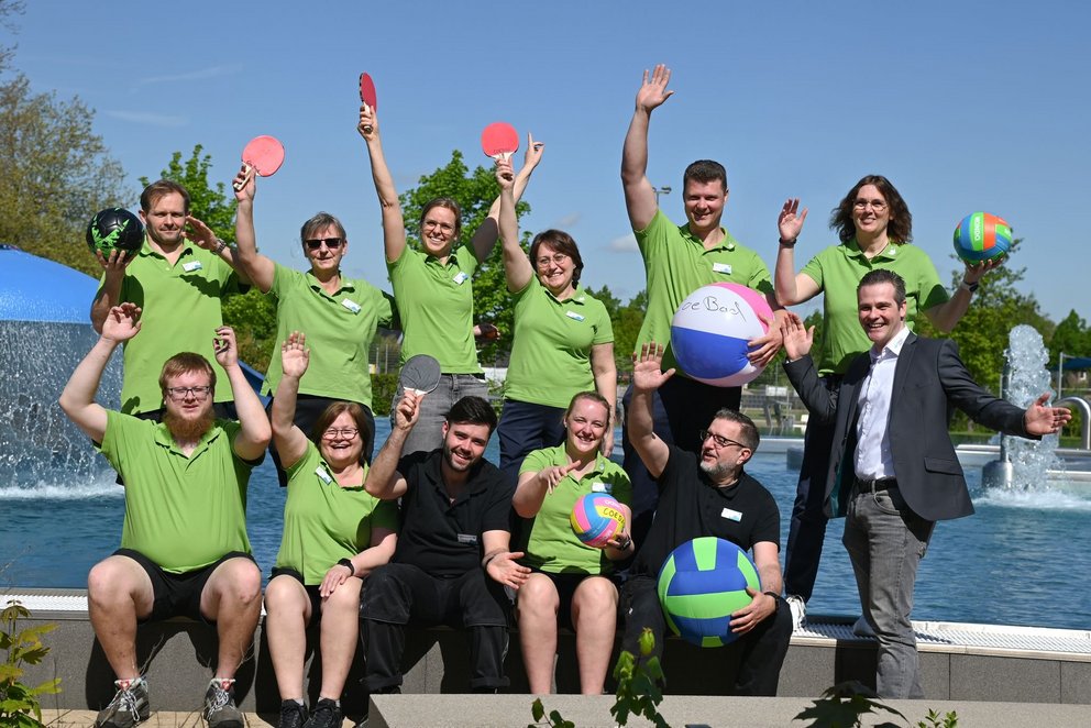 Gruppenfoto. . Mehrere Menschen in grünen Shirts stehen zusammen und lächeln für ein Gruppenfoto.