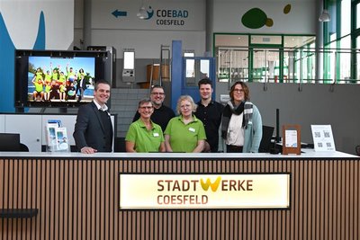 Eine Gruppe von Menschen steht zusammen an der Kassenbereich. 